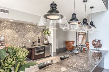 a kitchen and living room with glass pendant lights